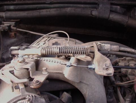 1993 Ford Bronco - Close-up view of the throttle linkage mechanism, showing the spring and cable assembly.