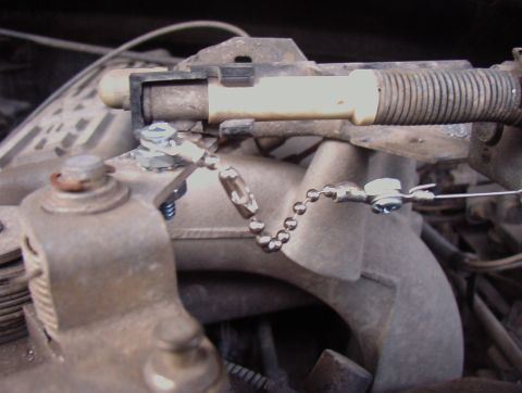 1993 Ford Bronco - Close-up of engine throttle linkage and cable assembly.