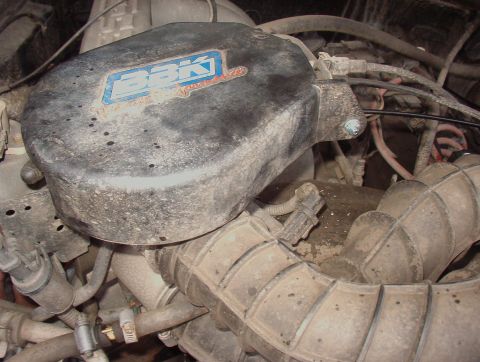 1993 Ford Bronco - The engine's air intake system, including a BBK air filter, is covered in dust and grime.