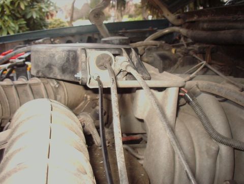 1993 Ford Bronco - Close-up view of engine bay components, including an air intake tube and a black electrical box.