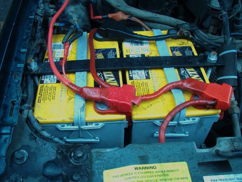 1993 Ford Bronco - Dual yellow Optima batteries are installed in the engine bay, connected with red cables.