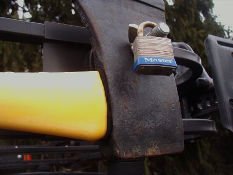 1993 Ford Bronco - An axe head is locked to a roof rack, with a yellow handle visible.