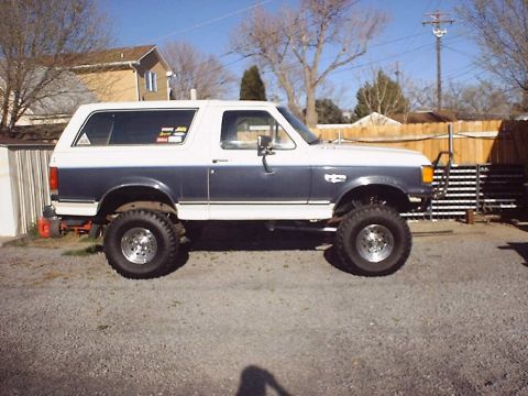 1988 Ford Bronco - This lifted 1988 Ford Bronco features a two-tone blue and white paint scheme and aftermarket wheels.