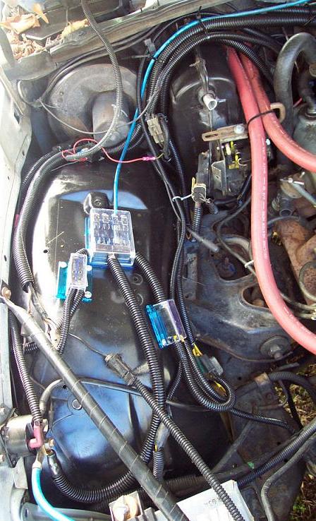 1985 Ford LTD Crown Victoria - Aftermarket fuse box and wiring installed in the engine bay, with visible red hoses.