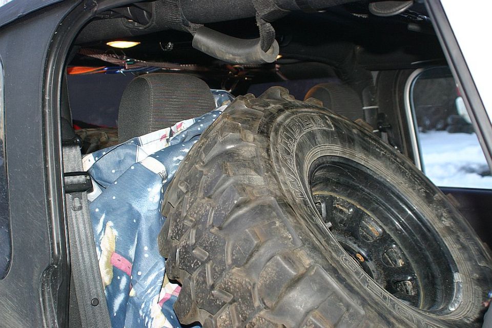 Spare tire and blankets loaded in the back of a vehicle