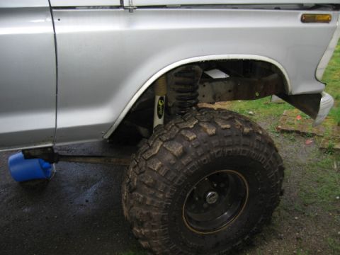 1976 Ford F-150 - Close-up of the lifted suspension and large off-road tire on a 1976 Ford F-150.