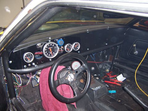 1971 Ford Mustang - The interior of a 1971 Ford Mustang shows a custom dashboard with multiple gauges and a roll cage.