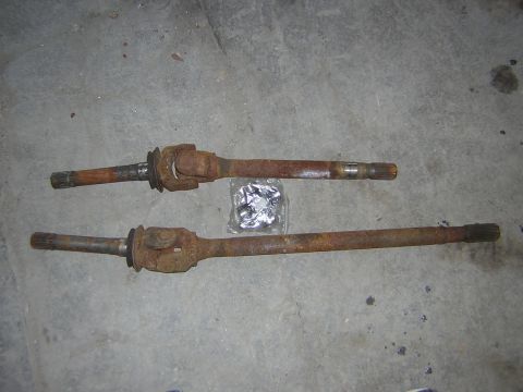 1995 Ford Bronco - Pair of used drive shafts, condition appears rusty, with a bag of fasteners.