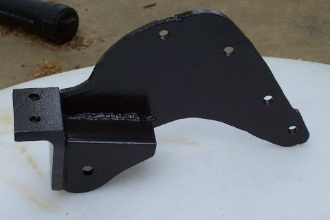 1994 Ford F-150 - A black metal bracket, likely a suspension component, is shown in detail against a light background.