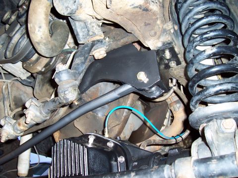 1994 Ford F-150 - Close-up view of a black track bar bracket, suspension parts, and a differential cover.