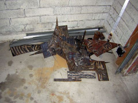 1995 Ford Bronco - Scrap metal welded into an abstract sculpture, lying on a concrete floor.