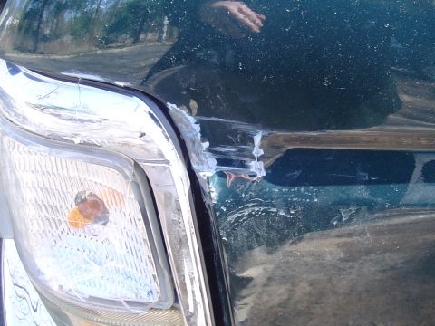 1993 Ford Bronco - Vehicle fender and headlight show significant damage from an impact.