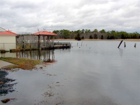 1995 Ford Bronco - A backyard scene shows significant flooding around a house and gazebo, with a dock extending into the water.