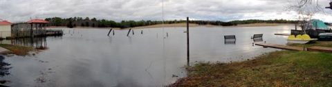 1995 Ford Bronco - Flooded area shows submerged benches and docks, with a paddleboat near a wooden pier.