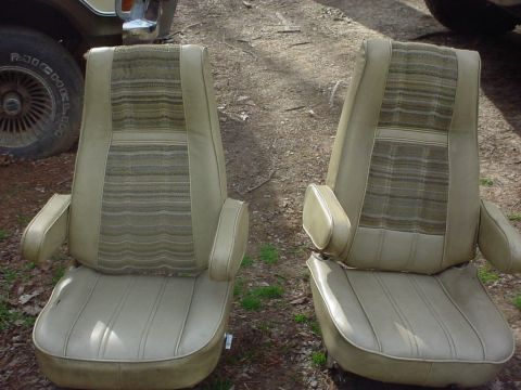 1979 Ford Bronco - Two car seats are shown from the front, with a tire and part of a vehicle visible in the background.