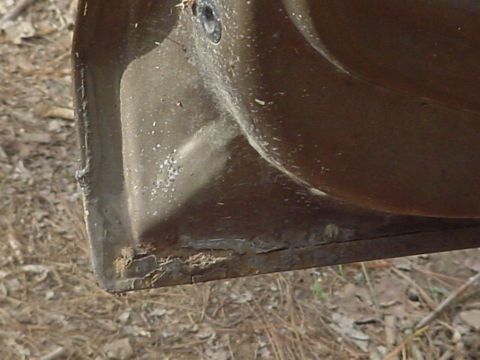 1979 Ford Bronco - Close-up of a corroded vehicle door corner, indicating wear and tear.