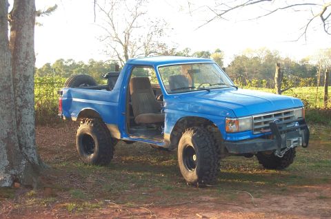 1987 Ford Bronco - Blue 1987 Ford Bronco modified for off-road use, showing its lifted suspension and large tires.