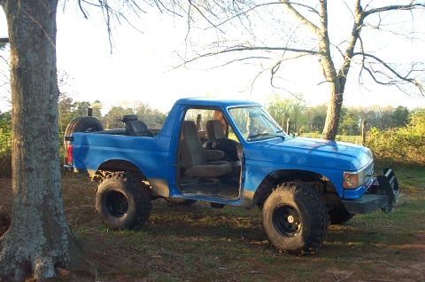 1987 Ford Bronco - This blue Ford Bronco, possibly a 1987 model, is equipped for off-road adventures with its lifted suspension and large tires.