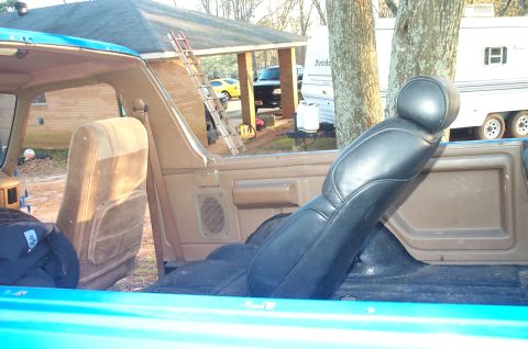1987 Ford Bronco - Interior view of a blue vehicle with brown seats and door panel.