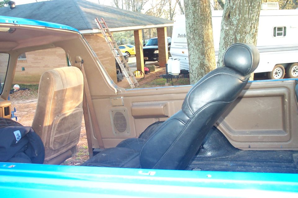 Interior view of a blue vehicle showing brown front seats and door panel