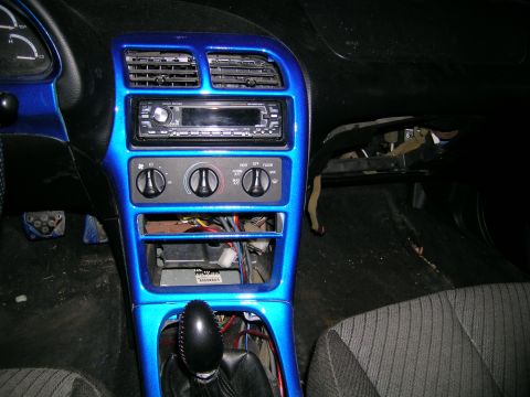 1994 Ford Probe - Interior view of a car's dashboard, showing custom paint and exposed wiring under the center console.