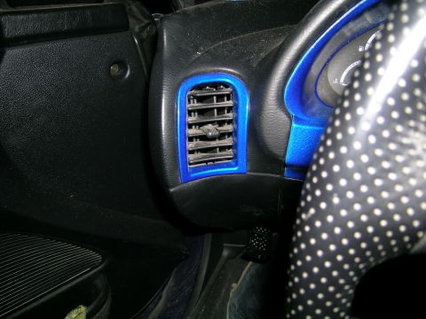 1994 Ford Probe - Close-up view of the interior dashboard, focusing on a blue-trimmed air vent and a portion of the steering wheel.