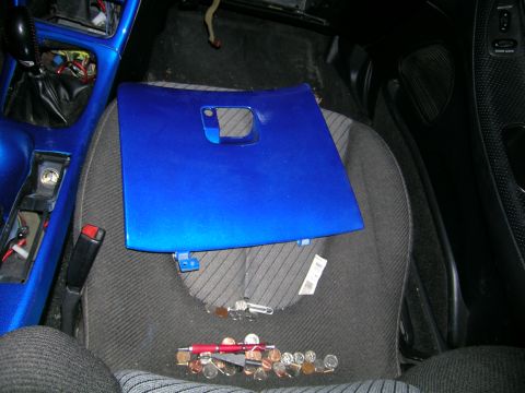 1994 Ford Probe - A blue panel rests on a car seat, with coins and a pen on the floor below.