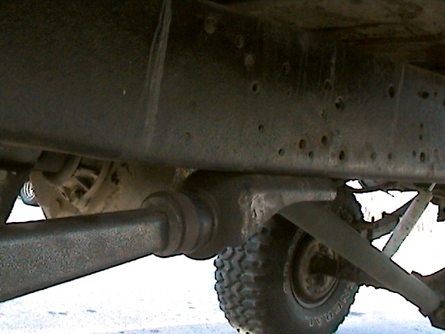 Underside of truck showing axle, differential, tie rod and off-road tire