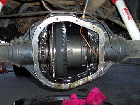 1994 Ford F-150 - Opened differential housing showing internal gears and components, with red rags and a drain pan below.