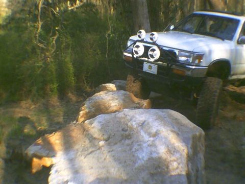 1991 Mazda Navajo - White SUV with auxiliary lights is shown off-roading on a rocky trail.
