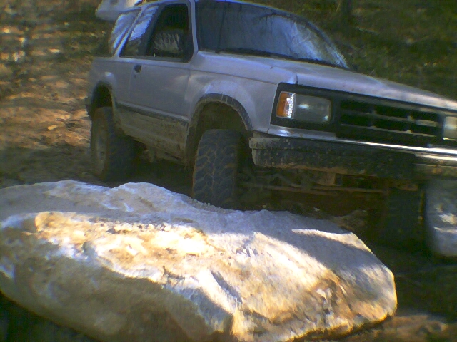1991 Mazda Navajo driving over a large rock, front 3/4 view