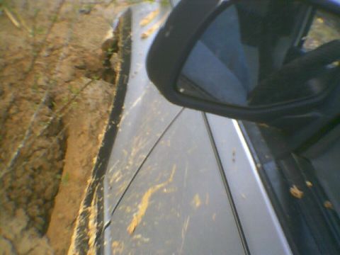 1991 Mazda Navajo - Vehicle is stuck in a muddy rut, with dirt and mud splattered on its side.