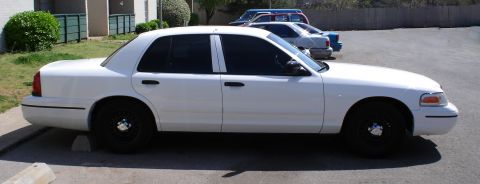 1998 Ford Crown Victoria - Side profile of a white 1998 Ford Crown Victoria with black wheels parked outdoors.