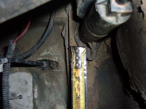1985 Ford F-150 - Measuring a component on a vehicle frame, possibly for clutch repair.