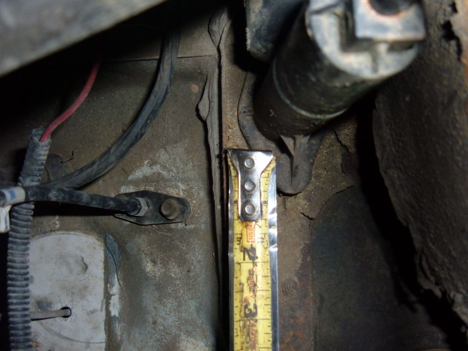 Close-up of vehicle frame with a yellow measuring tape showing approximately 2.5 inches