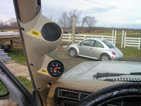 1984 Ford Bronco - An Auto Meter gauge pod is mounted inside a vehicle, showing an oil pressure gauge and a speaker opening.