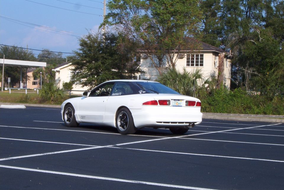 White Ford Probe GT rear three-quarter view with dark five-spoke wheels in an empty parking lot