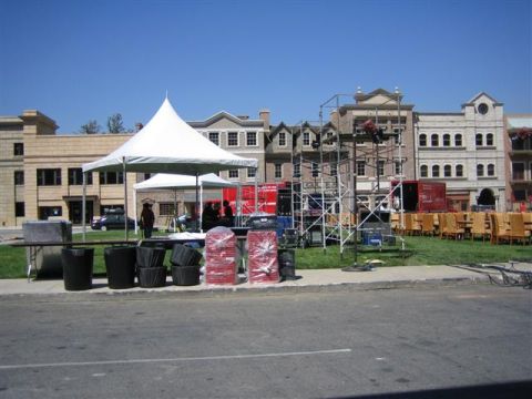 1994 Ford Bronco - An outdoor scene depicts a setup for an event, tents, scaffolding, and chairs arranged in front of buildings.