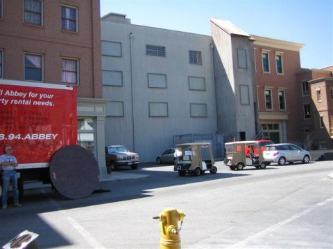 1994 Ford Bronco - Several golf carts and a pickup truck are parked on a street in front of various buildings.