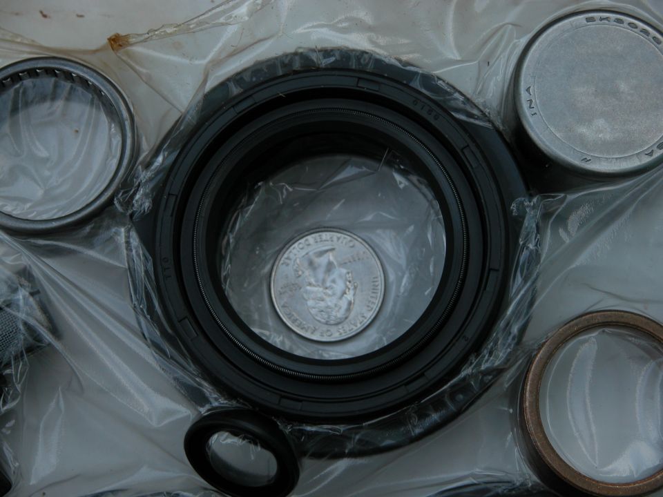 New rubber lip seal and needle bearings in plastic bags with quarter for scale
