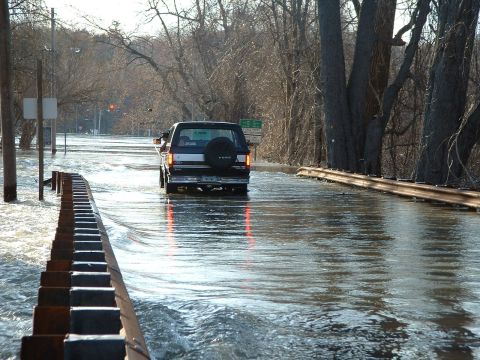 1993 Ford Bronco - A 1993 Ford Bronco navigates a flooded road, with water reaching up to its doors.
