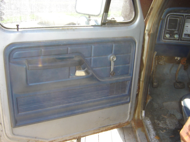 Interior of a 1979 Ford F-Series truck showing the driver's side door panel and part of the dashboard