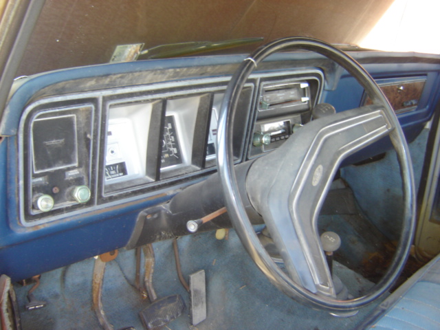 Dashboard and steering wheel of an older truck. Shows the instrument cluster and radio