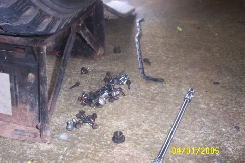 1979 Ford F-150 - Disassembled engine components and a socket wrench lie on a garage floor.