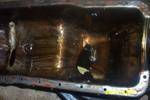 1979 Ford F-150 - A close-up view of a dirty oil pan, showing the date stamp 04/01/2005.