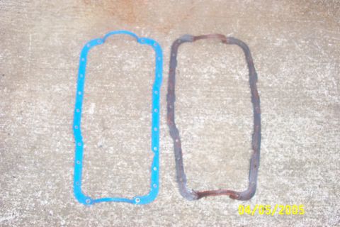 1979 Ford F-150 - Comparing a new blue oil pan gasket to an old, corroded one on a concrete surface.
