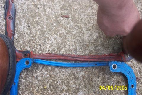 1979 Ford F-150 - A close-up view shows an engine gasket with red and blue sealant on a concrete surface.