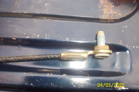 1979 Ford F-150 - A close-up view of a cable assembly attached to a bolt on a dark blue surface.