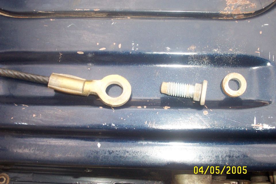 Cable lug with a bolt and washer next to it on a dark blue surface