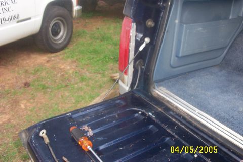 1979 Ford F-150 - Close-up of a pickup truck's tailgate and interior, with another truck in the background.